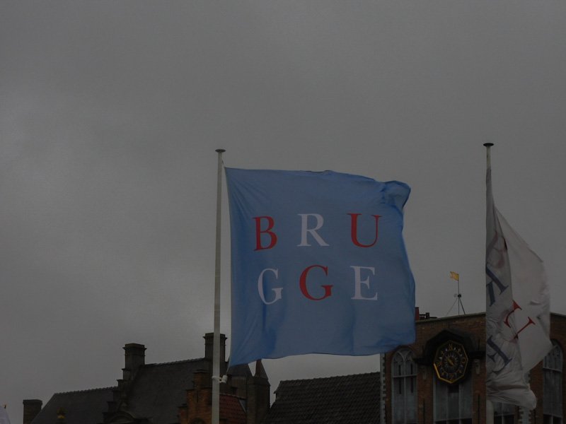 Flag that reads BRUGGE in the city's Markt, one of the main stops on a weekend in Belgium.