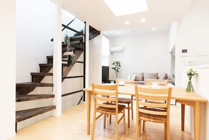 A cozy living room and dining area with stairs leading up to second floor