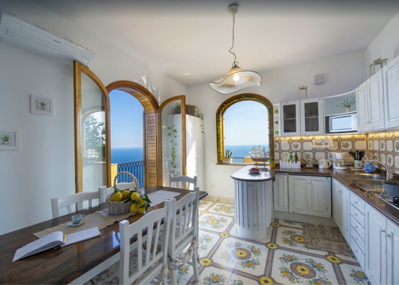 Charming kitchen in villa in Italy for rent with access to a balcony that overlooks the Amalfi Coast.