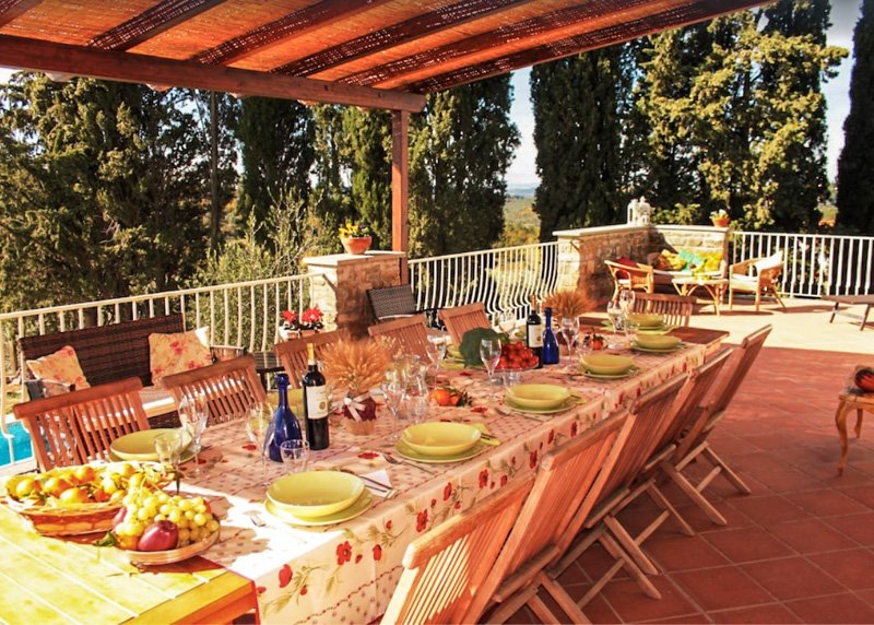 A large outdoor table to enjoy a meal together at this Italian villa for rent.