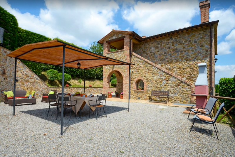 A traditional Tuscan villa in Italy for rent with lots of outdoor seating.